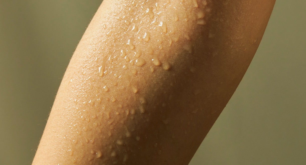 Gros plan sur la texture de la peau d'un bras avec gouttes d'eau